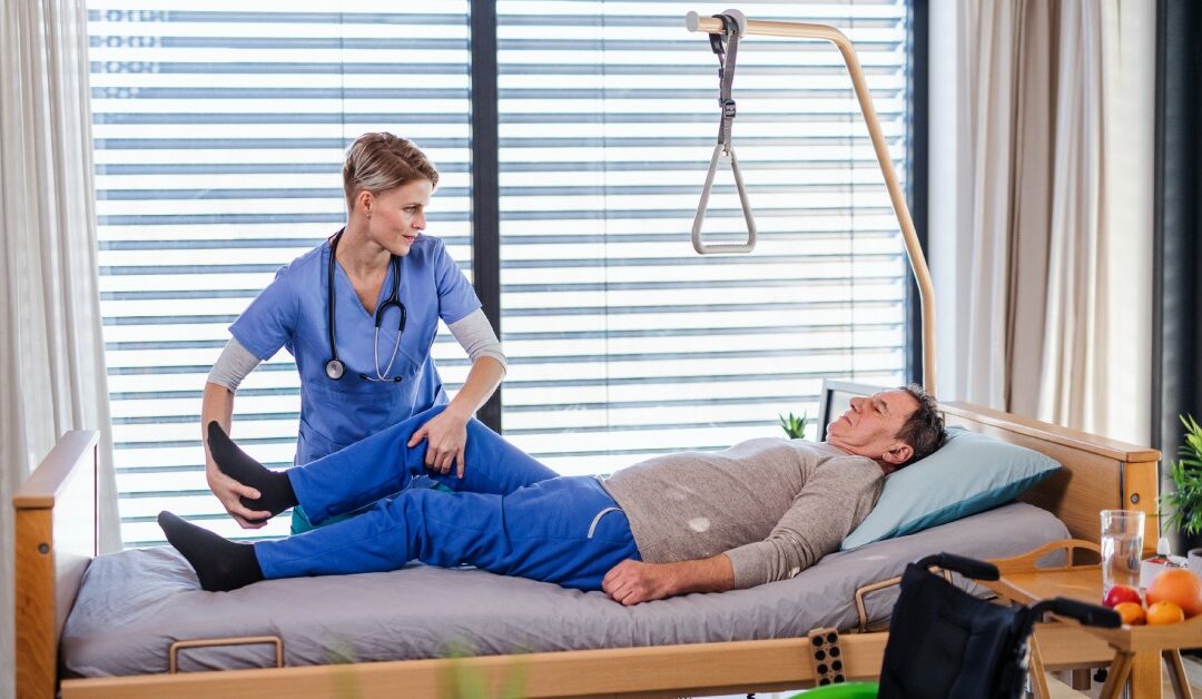 A patient lying on a hospital bed with his head slightly elevated as a physical therapist gently raises his right leg.